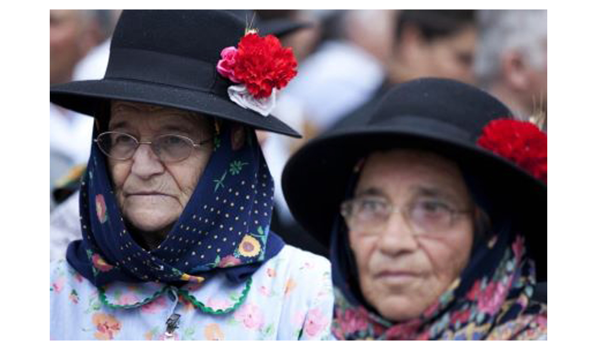 cravos de Abril duas mulheres mais velhas com cravos no chapéu